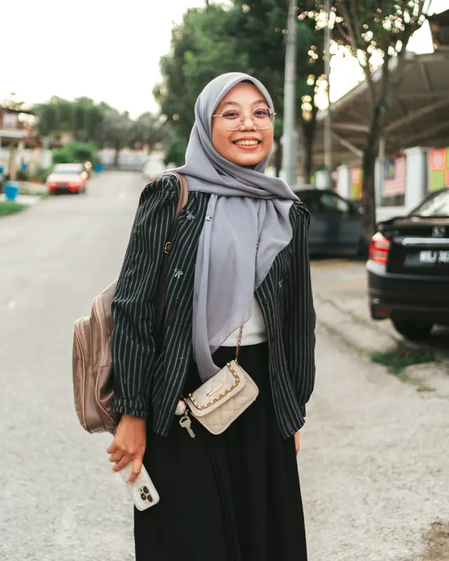 A smiling woman holding her phone